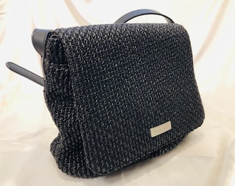 Nine West-A black crocheted cross body saddle bag with a large flap, distinctive Nine West logo & adjustable strap. Stylish,sturdy,practical