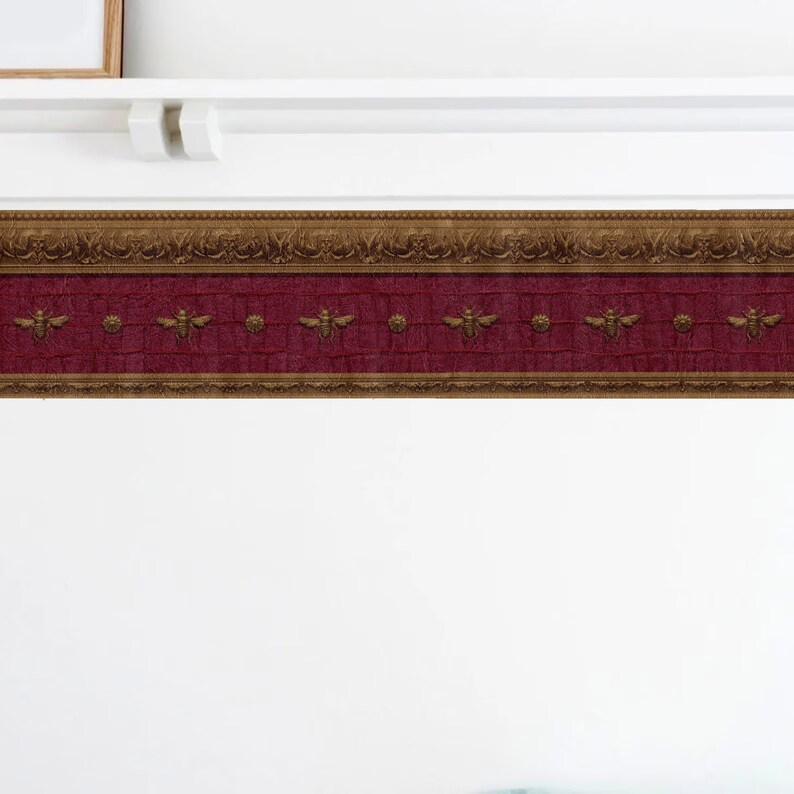 May include: A decorative wallpaper border with a burgundy background and gold accents. The border features a repeating pattern of bees and ornate designs.