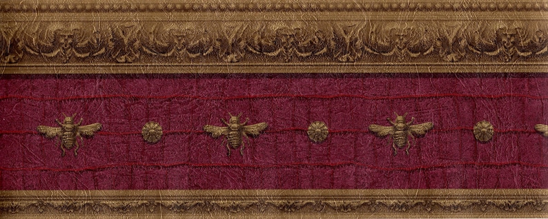 Raymond Waites Napoleonic Bee wallpaper border in maroon and burnished gold, featuring gold bees and medallions on a textured faux leather background.