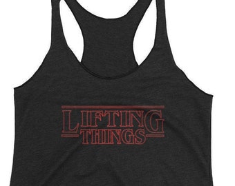 May include: Black tank top with a red graphic that says "Lifting Things" in a style reminiscent of the Stranger Things logo.