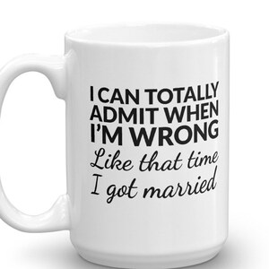 May include: White ceramic coffee mug with a black inscription that reads "I can totally admit when I'm wrong Like that time I got married".