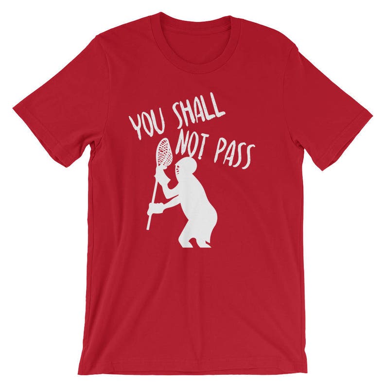 May include: Red t-shirt with white text that says "You Shall Not Pass" and a white silhouette of a person holding a lacrosse stick.