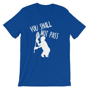 May include: A royal blue t-shirt with white text that reads "You Shall Not Pass" and a white silhouette of a lacrosse player holding a lacrosse stick.
