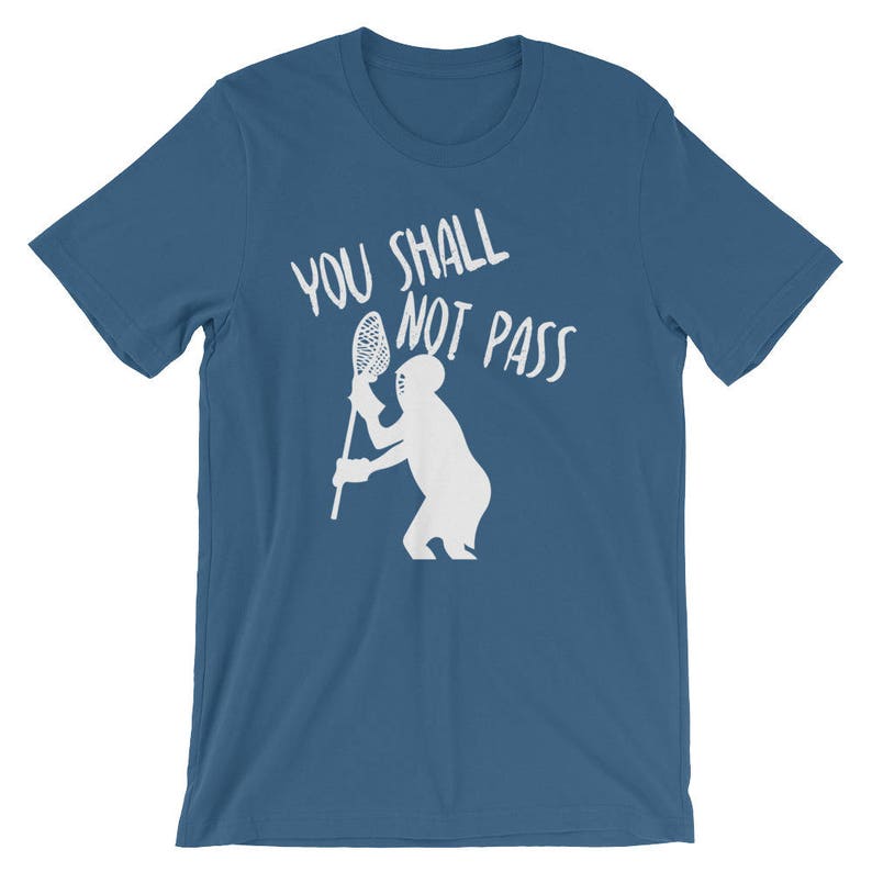 May include: A blue t-shirt with white text that reads "You Shall Not Pass" and a white silhouette of a lacrosse player holding a lacrosse stick.