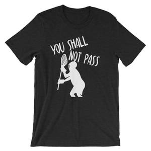 May include: A black t-shirt with a white silhouette of a lacrosse player holding a lacrosse stick and the text "You Shall Not Pass".