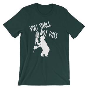 May include: A dark green t-shirt with a white graphic of a lacrosse player holding a lacrosse stick and the text "You Shall Not Pass".