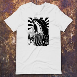 May include: Black and white graphic t-shirt featuring a stylised image of a wave crashing over a city skyline. The text "ひょうたん型" is printed on the right side of the design.