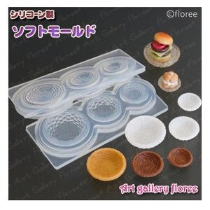 Puede incluir: Molde de silicona transparente con varias formas circulares, junto con modelos de comida en miniatura. El molde tiene patrones texturizados. También hay varias miniaturas de comida detalladas, incluyendo una hamburguesa y platos pequeños. El texto "art gallery floree" es visible.