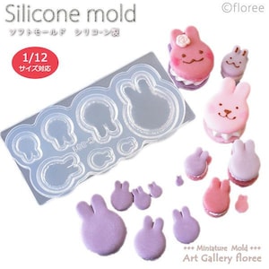 May include: A clear silicone mold with multiple bunny shapes, including a large bunny, smaller bunnies, and tiny bunny ears. The mold is designed for making miniature bunny-shaped cakes or other treats. The image also shows several finished bunny-shaped cakes in pink and purple.