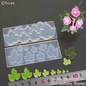 May include: Two clear silicone moulds for making miniature ivy leaves. The moulds are filled with small, detailed ivy leaf shapes. A ruler is shown with miniature green ivy leaves made with the moulds.