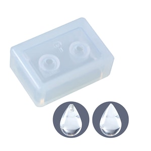 May include: A clear silicone mould for making teardrop-shaped resin pendants. The mould has two cavities and is shown with two clear resin pendants.