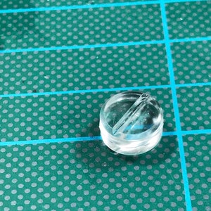 Puede incluir: Una cuenta de plástico transparente con una pequeña ranura que atraviesa la parte superior.