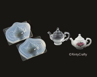 May include: Two clear silicone molds shaped like teapots, and three miniature teapots. One teapot is clear glass, one is white with a floral design, and one is white.