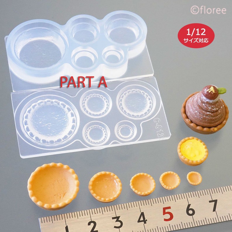 May include: A set of clear silicone moulds for making miniature tarts and pies. The moulds are in two parts, with one part featuring a scalloped edge. The moulds are shown with several finished miniature tarts in various sizes, ranging from 2.5 to 7.5 cm in diameter. The image also includes a ruler for scale.