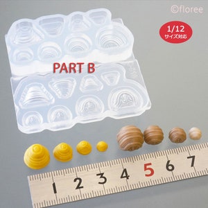 May include: A clear silicone mould with 12 different shapes for making miniature food items. The mould is labelled "PART B". The image also shows several miniature food items made with the mould, ranging in size from 1 to 7 centimetres.