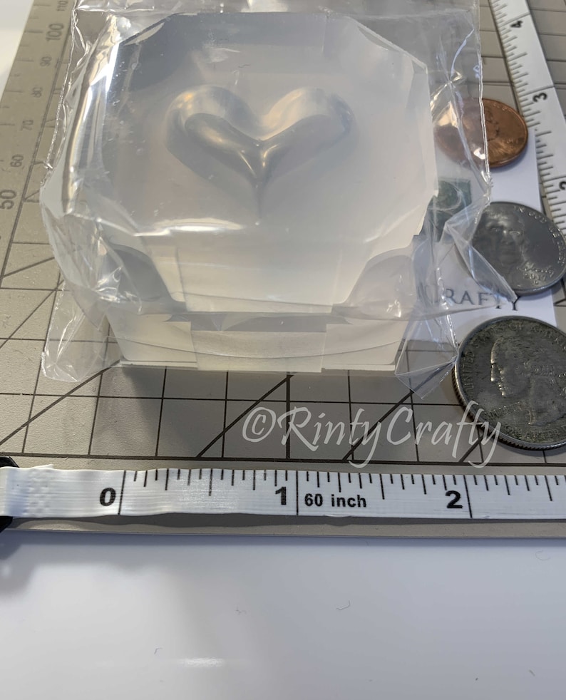 May include: Clear silicone mold shaped like a heart, measuring approximately 1 inch in diameter. The mold is packaged in a clear plastic bag.