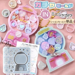 May include: A selection of pink and blue gumball machine-shaped moulds and accessories. The image includes various heart, star, and gem-shaped resin pieces, along with the text "MAGIC CAPSULE" and Japanese text.