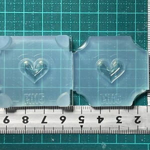May include: Two clear silicone molds with a heart shape design. The molds are labeled "PH15".