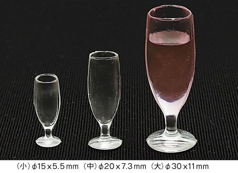 May include: Three clear glass champagne flutes of different sizes. The smallest flute is 15 mm in diameter and 5.5 mm tall. The middle flute is 20 mm in diameter and 7.3 mm tall. The largest flute is 30 mm in diameter and 11 mm tall.