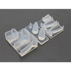 May include: Clear silicone mold with multiple cavities for creating resin crafts. The mold features a variety of shapes, including pointed tips and curved forms.