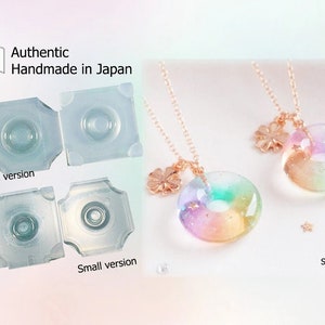 May include: The image shows clear, square moulds marked "Large version" and "Small version." Two necklaces with rainbow-hued, donut-shaped pendants and gold chains are also visible. The text "Authentic Handmade in Japan" is displayed.