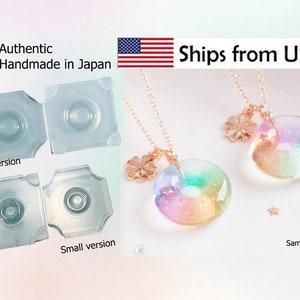 May include: The image showcases two clear, plastic molds labeled "Large version" and "Small version." Two necklaces with iridescent, donut-shaped pendants and gold chains are also displayed. The pendants have a flower charm. The text "Authentic Handmade in Japan" is visible.