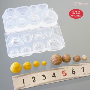 May include: A clear silicone mould with 12 different shapes for making miniature food items. The mould is shown with several small, yellow and brown, resin-cast food items. A ruler is included for scale, showing the items are approximately 1.2 cm in size. The text "1/12 サイズ対応" is visible on the mould.