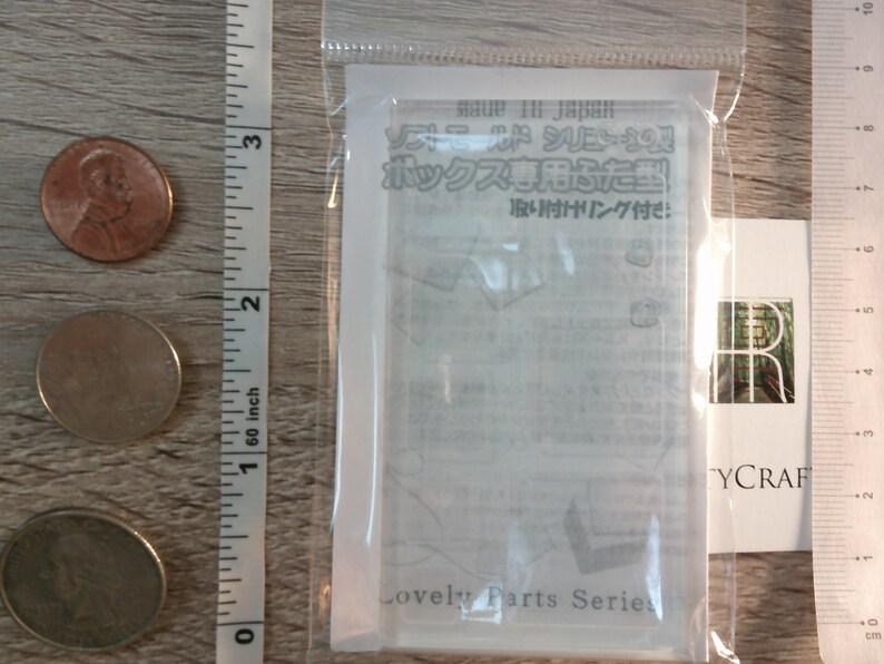 May include: A clear plastic packaging containing a white card with Japanese text that reads "Soft Mold Series Box Lid Mold with Attachment Ring Included." The card also has the text "Lovely Parts Series" at the bottom.