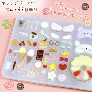 Op de afbeelding: Een doorzichtige tray gevuld met 42 verschillende miniatuurharsvormen in diverse vormen, waaronder voedsel zoals ijsjes, donuts en een koffiekopje, samen met decoratieve elementen zoals kronen en strikken. De tekst in de afbeelding zegt "42 soorten!!" en "Onbeperkte rangschikking".