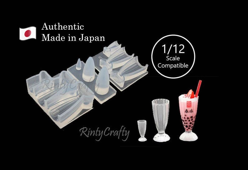 May include: A clear silicone mold for making miniature 1/12 scale drinking glasses. The mold has four cavities, each shaped like a different style of glass. The mold is labeled "1/12 Scale Compatible".