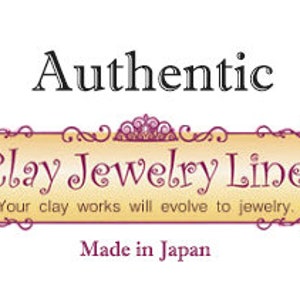 May include: A logo for Clay Jewelry Line, a company that makes jewellery from clay. The logo is on a yellow banner with a gold crown and scrollwork. The text "Authentic Clay Jewelry Line" is in black, and the text "Your clay works will evolve to jewellery." is in a smaller font. The text "Made in Japan" is at the bottom of the banner.