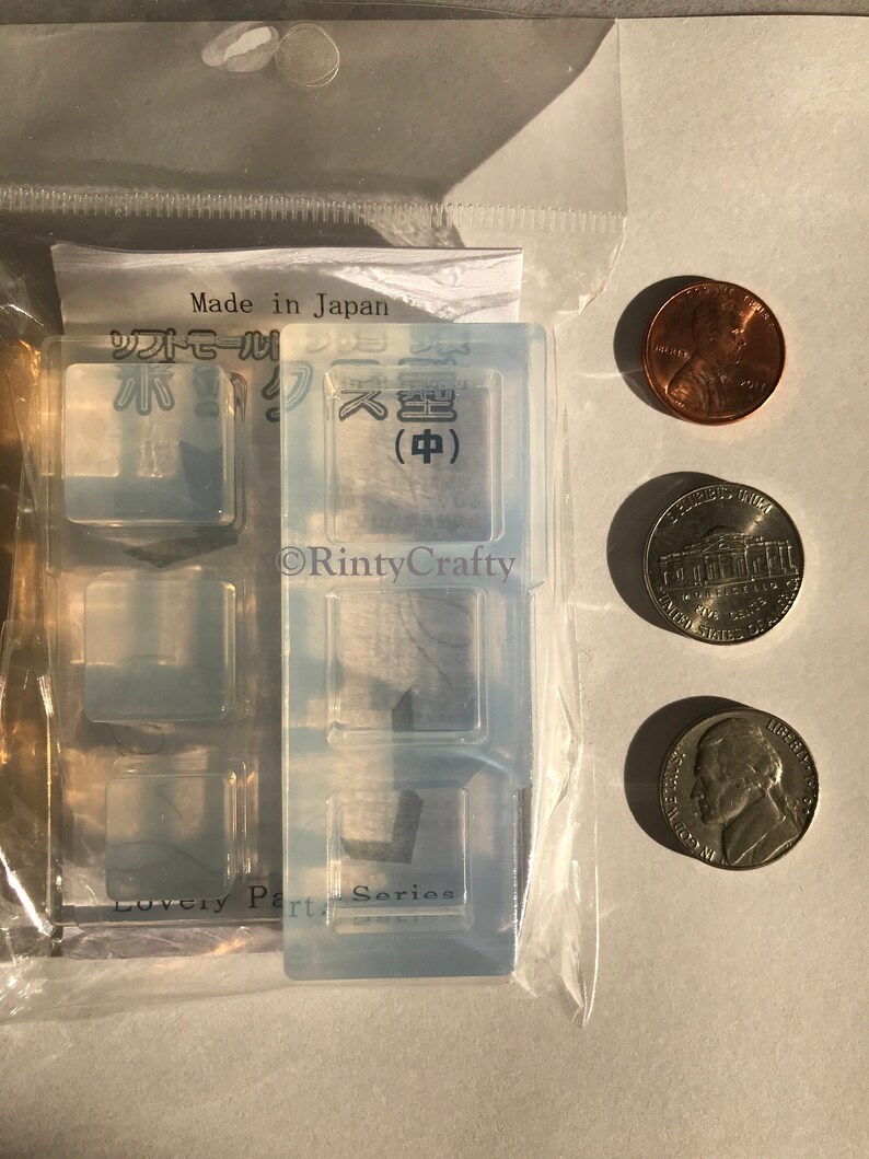May include: A clear silicone mold with four square cavities. The mold is labeled "Lovely Part Series" and has Japanese text that reads "Made in Japan" and "Soft Seal". The mold is packaged in a clear plastic bag with three US coins for scale.