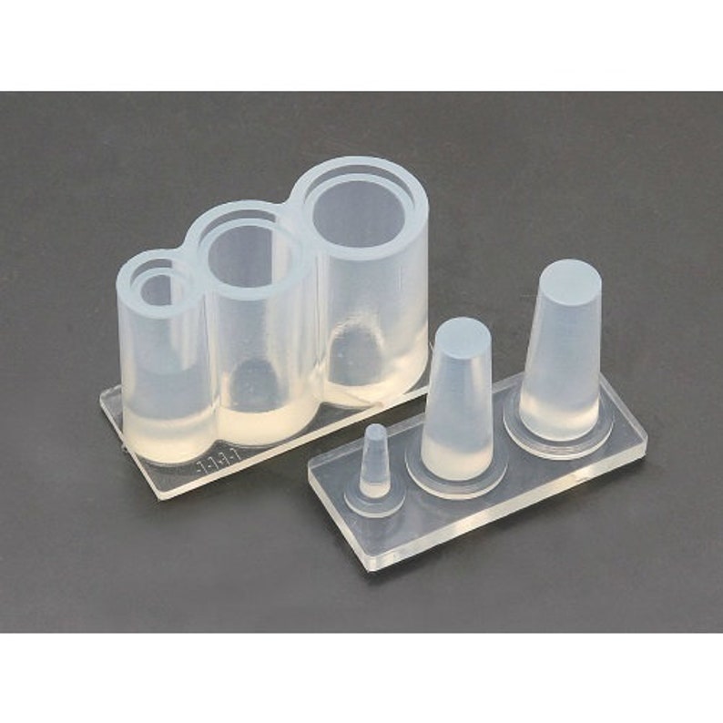 May include: A set of clear silicone molds for making rings. The molds are on a clear plastic base. The molds are in different sizes and shapes.