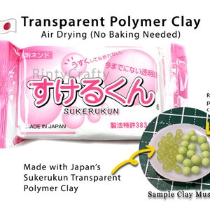 Op de afbeelding: Een verpakking Sukerukun Transparante Polymer Clay, een Japanse luchtdrogende klei die niet gebakken hoeft te worden. De verpakking is roze en wit met Japanse tekst die "Sukerukun" en "Made in Japan" luidt. Een voorbeeld van de klei is getoond in de vorm van groene muskaatdruiven.
