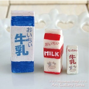 Puede incluir: Tres cartones de leche en miniatura, uno grande, uno mediano y uno peque&ntilde;o. Los cartones son blancos con detalles azules, rojos y verdes. Los cartones tienen texto japon&eacute;s que dice "Oichii", que significa "delicioso", y "Leche". Los cartones est&aacute;n hechos de arcilla polim&eacute;rica.