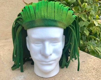 May include: A green felt wig with long, fringed strands. The wig is worn on a white mannequin head.