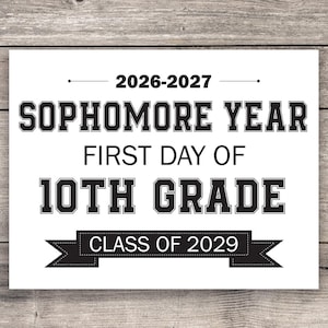 May include: A white rectangular sign featuring black text that reads 2026-2027, SOPHOMORE YEAR, FIRST DAY OF, 10TH GRADE, and a black banner graphic containing the text CLASS OF 2029. The design uses bold, block-style lettering for the main headings.
