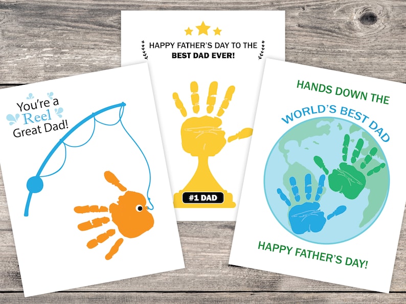 May include: Three Father's Day cards with handprint designs. The first card says "You're a Reel Great Dad!" and features a blue fishing rod with an orange handprint fish. The second card says "Happy Father's Day to the Best Dad Ever!" and features a yellow handprint trophy. The third card says "Hands Down the World's Best Dad" and features a blue and green handprint on a globe.