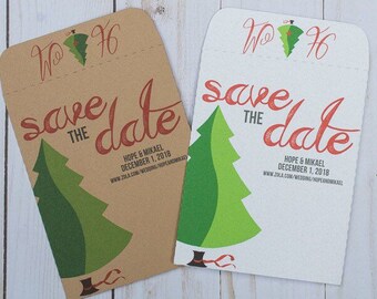 May include: Two save the date cards with a green Christmas tree design. The text on the cards reads "Save the Date" with the names "Hope & Mikael" and the date "December 1, 2018". The website address "www.zola.com/wedding/hopeandmikael" is also included.