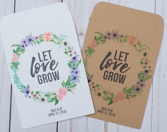 May include: Two white and brown paper envelopes with a floral wreath design. The text "Let love grow" is printed in black on both envelopes. The envelopes are for wedding favors and include the date "April 21, 2018".