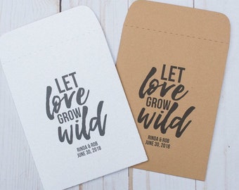 May include: Two kraft paper envelopes with the text "Let love grow wild" printed in black. The envelopes are blank on the back and have a white stitched seam. The text "Rinda & Rob June 30, 2018" is printed below the main text on both envelopes.