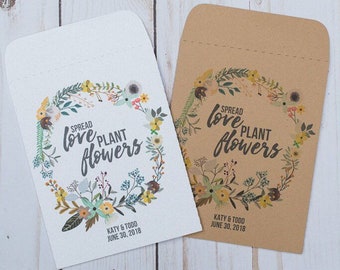 May include: Two white and brown paper envelopes with a floral wreath design. The text on the envelopes reads "Spread love plant flowers" and "Katy & Todd June 30, 2018".