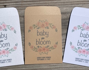 May include: Three white and brown paper envelopes with a floral design and the text "baby in bloom" and "Sarah's Baby Shower September 21, 2022".