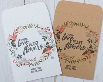 May include: Two white and brown paper envelopes with a floral wreath design. The text on the envelopes reads "Spread love plant flowers" with the names "Katy & Todd" and the date "June 30, 2018".