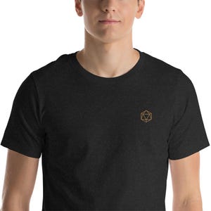 Peut inclure: Un t-shirt noir avec un motif géométrique brodé en or.