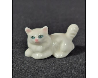 Miniaturowa biała porcelanowa figurka kota z niebieskimi oczami i różowym nosem, mała kolekcjonerska