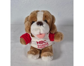 Souvenir vintage degli studi NBC di Burbank, California, con cucciolo di peluche marrone, bianco e con maglietta rossa.