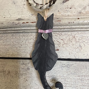May include: Black wooden cat silhouette ornament with a pink ribbon and a silver charm that says "I love my cat".