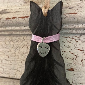 May include: Black wooden cat ornament with a pink ribbon and a silver charm that says "Love My Cat".