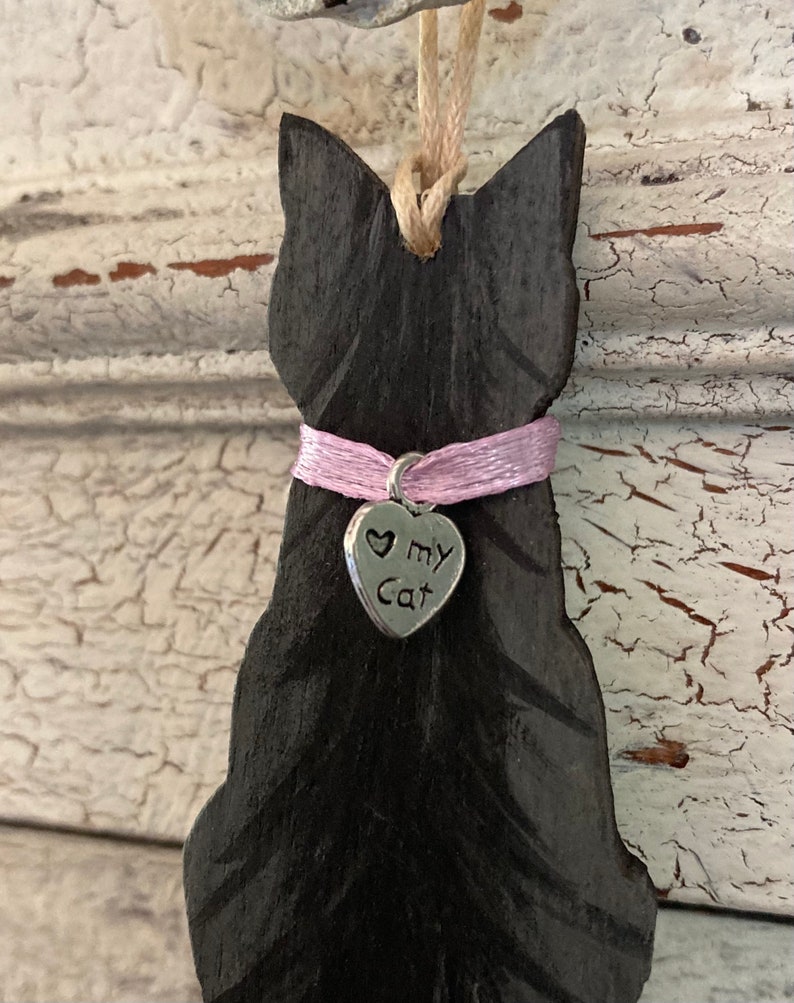 May include: Black wooden cat ornament with a pink ribbon and a silver charm that says "Love My Cat".